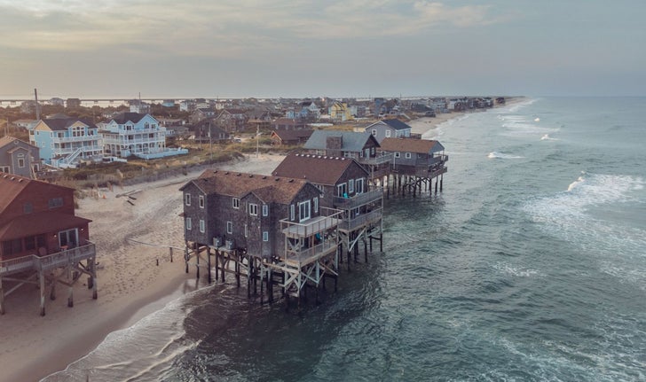 Les maisons en les plus à droite du groupe se sont effondrées le 20 septembre. La deuxième maison du groupe à partir de la gauche s’est effondrée le 24 septembre. Sur la plage de la ville de Rodanthe, au coin de America drive, la largeur de la plage a tellement rétréci que ces maisons se retrouvent littéralement les pieds dans l’eau.